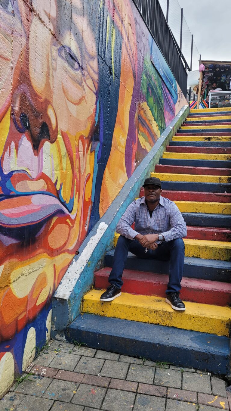 Shep on the outdoor stairs in Comuna 13, Medellín — an American living in Colombia since 2020