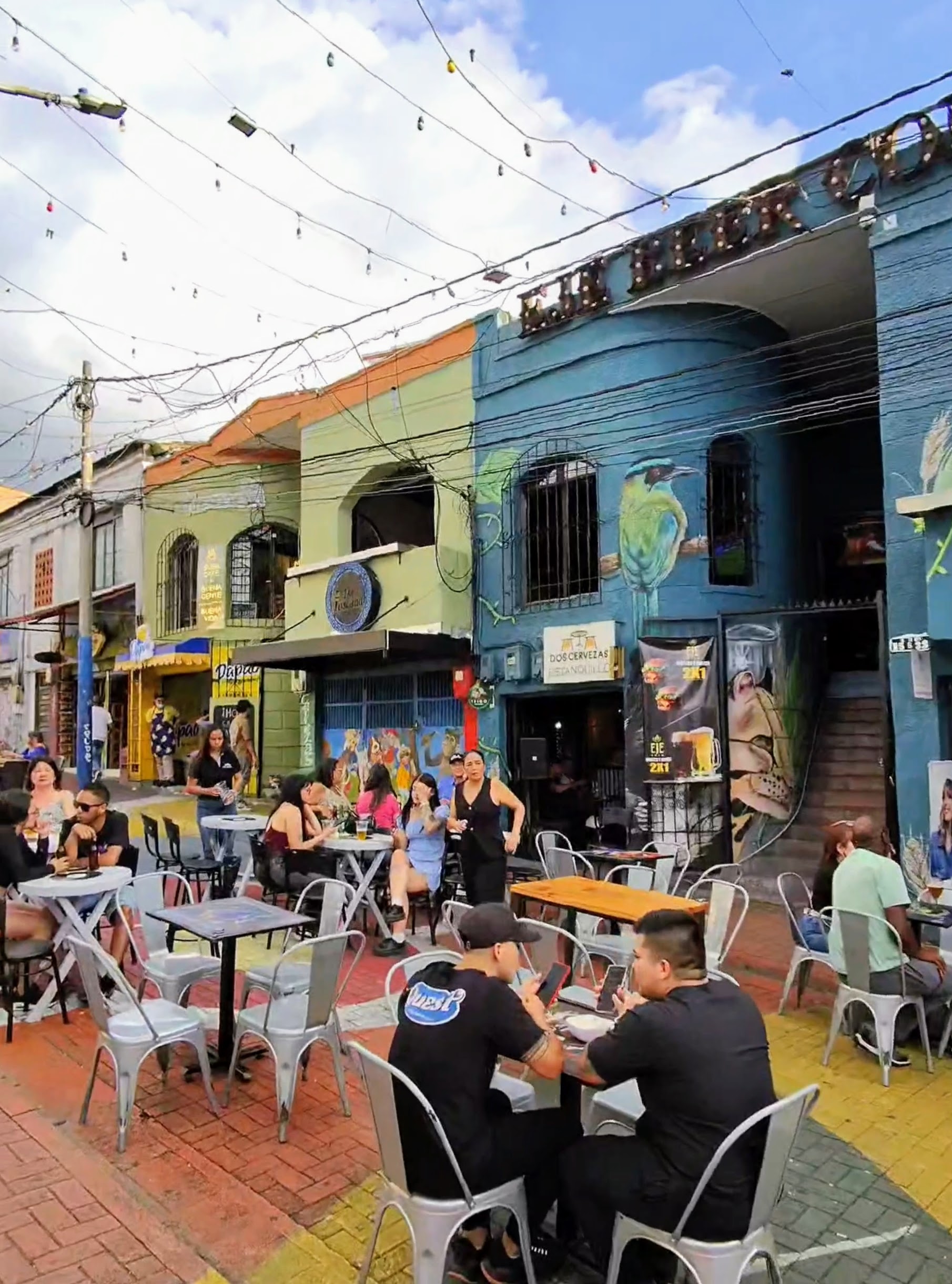 People eating outside on a lively, colorful street in Pereira, Colombia