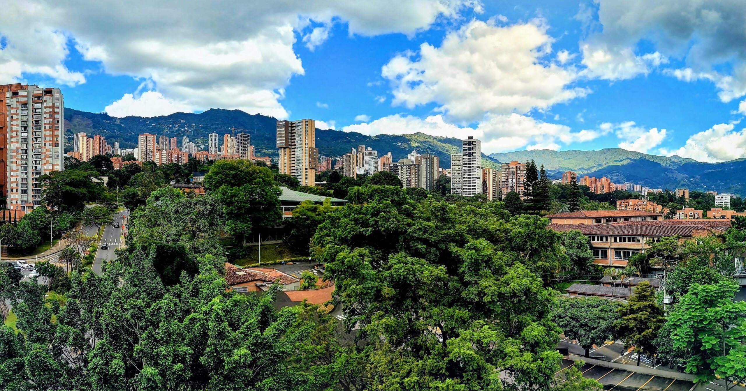 Panoramic view over the El Poblado district of Medellín, Colombia, with apartment towers among trees below the Andes