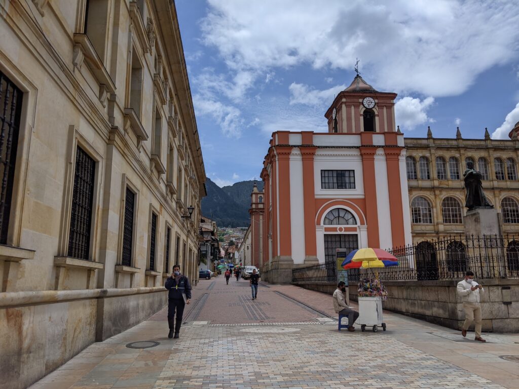 A street in La Candelaria, Bogota, with colonial buildings and the Andes behind, photographed by the author